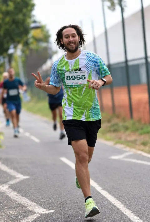 Yakov running a race, smiling and flashing a peace sign